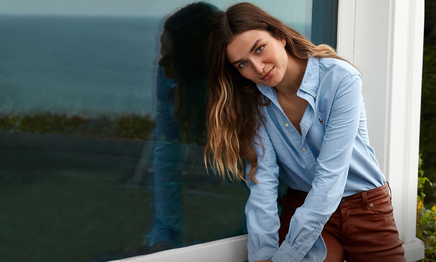 Woman in light blue oxford shirt with embroidered Polo Pony at chest